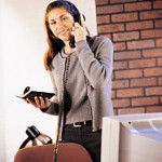 brunette on phone with brick wall
